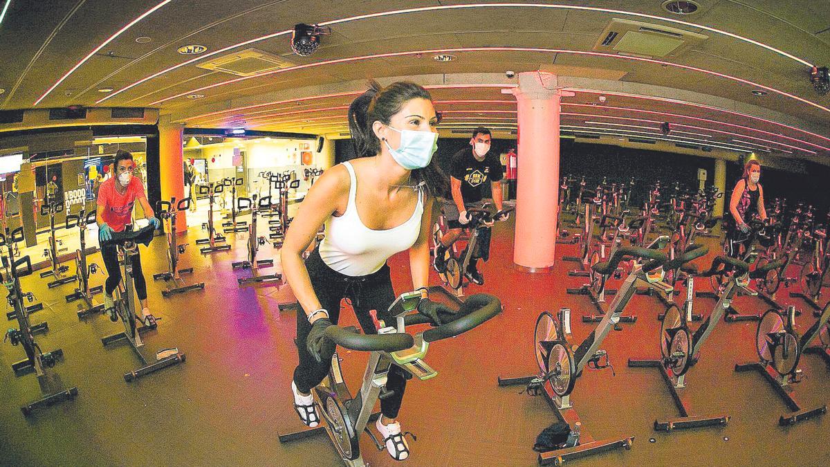 Usuarios de un gimnasio practican ‘spinning’ con la mascarilla puesta en una imagen de archivo.