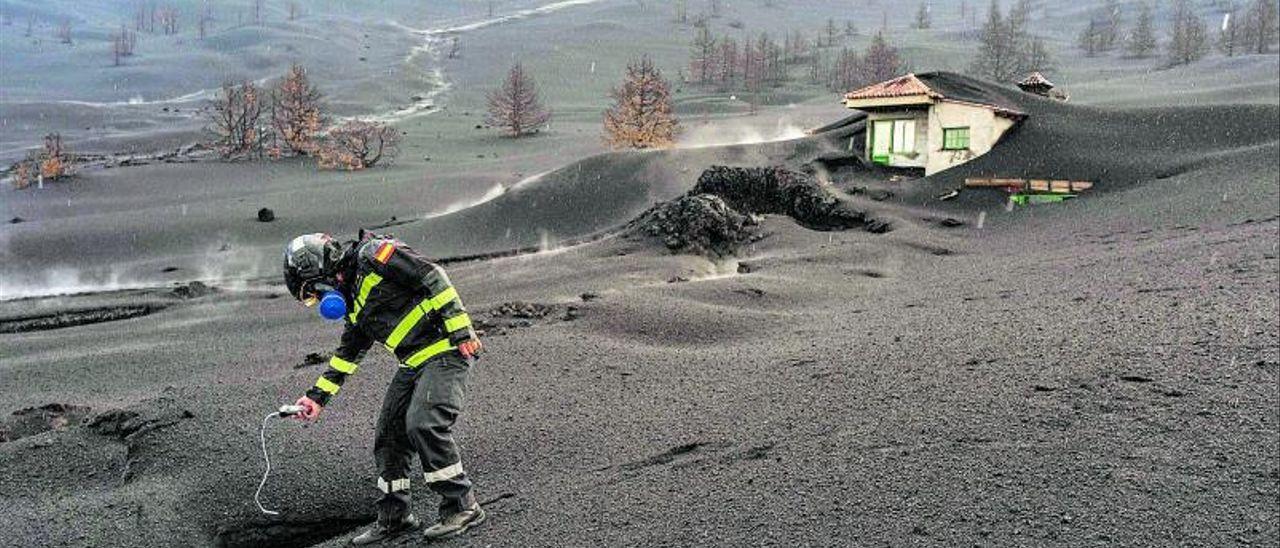 Un efectivo de la Unidad Militar de Emergencias (UME) mide los gases que emanan del volcán en la zona de exclusión.