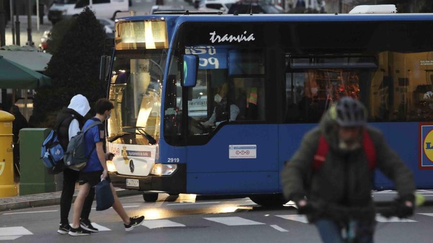 Dos peatones cruzan por delante de un autobús en Las Meanas. | Ricardo Solís