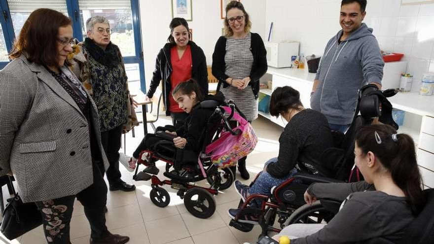 Por la izquierda, Natalia González y Ana González saludan a un grupo de usuarios.