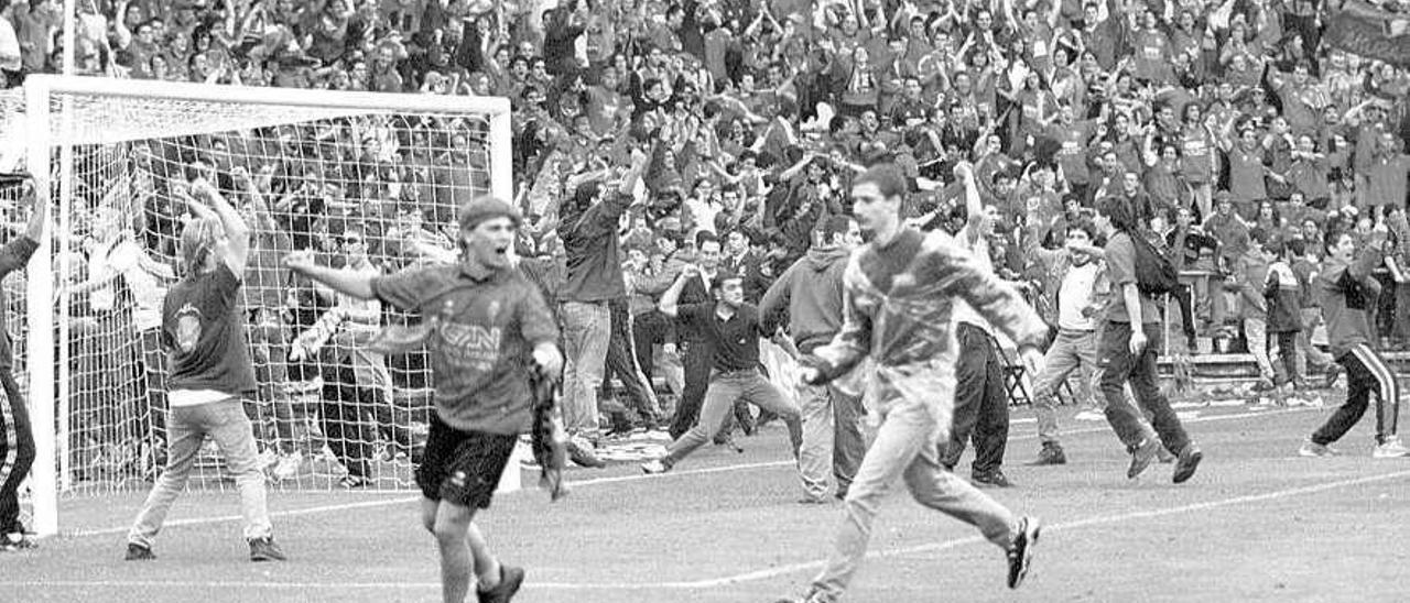 Los aficionados de Osasuna saltan al terreno de juego de El Molinón para celebrar el gol de Iván Rosado.