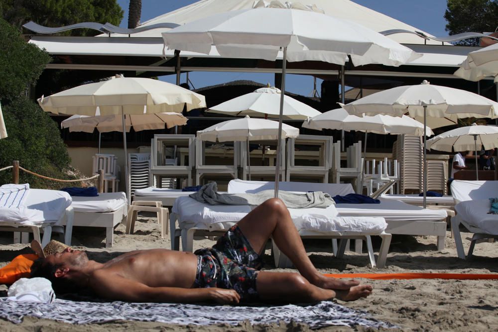 Un bañista descansa sobre su toalla frente a una de las concesiones de ses Salines.