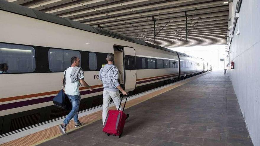 Dos viajeros suben al tren de alta velocidad en la estación de Os Eidos. // Cristina Graña