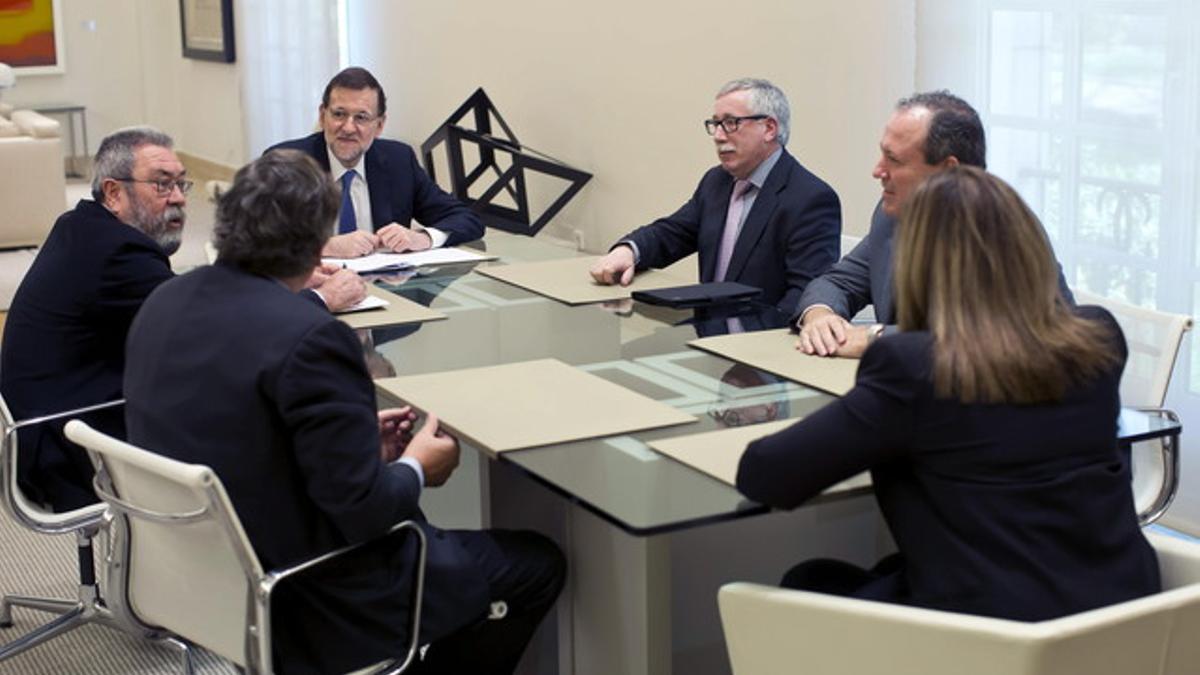 Mariano Rajoy y la ministra de Empleo, Fátima Báñez, con los dirigentes sindicales y empresariales en la reunión del diálogo social del 18 de marzo del 2014.