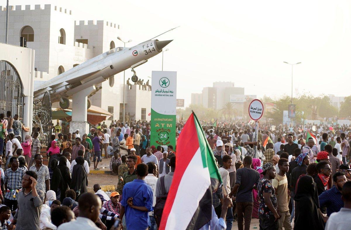 Sudanese demonstrators hold national flags and chant slogans as they protest against the army s announcement that President Omar al-Bashir would be replaced by a military-led transitional council  outside Defence Ministry in Khartoum  Sudan April 11  2019  REUTERS Stringer