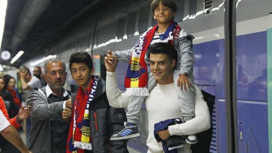 Mohsen y sus dos hijos, con bufandas, anoche, en Barcelona. // Efe