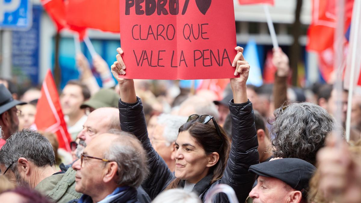 Una mujer sujeta un cartel durante una concentración en la calle de Ferraz en apoyo al presidente del Gobierno, Pedro Sánchez, en la sede del PSOE, a 27 de abril de 2024, en Madrid (España).