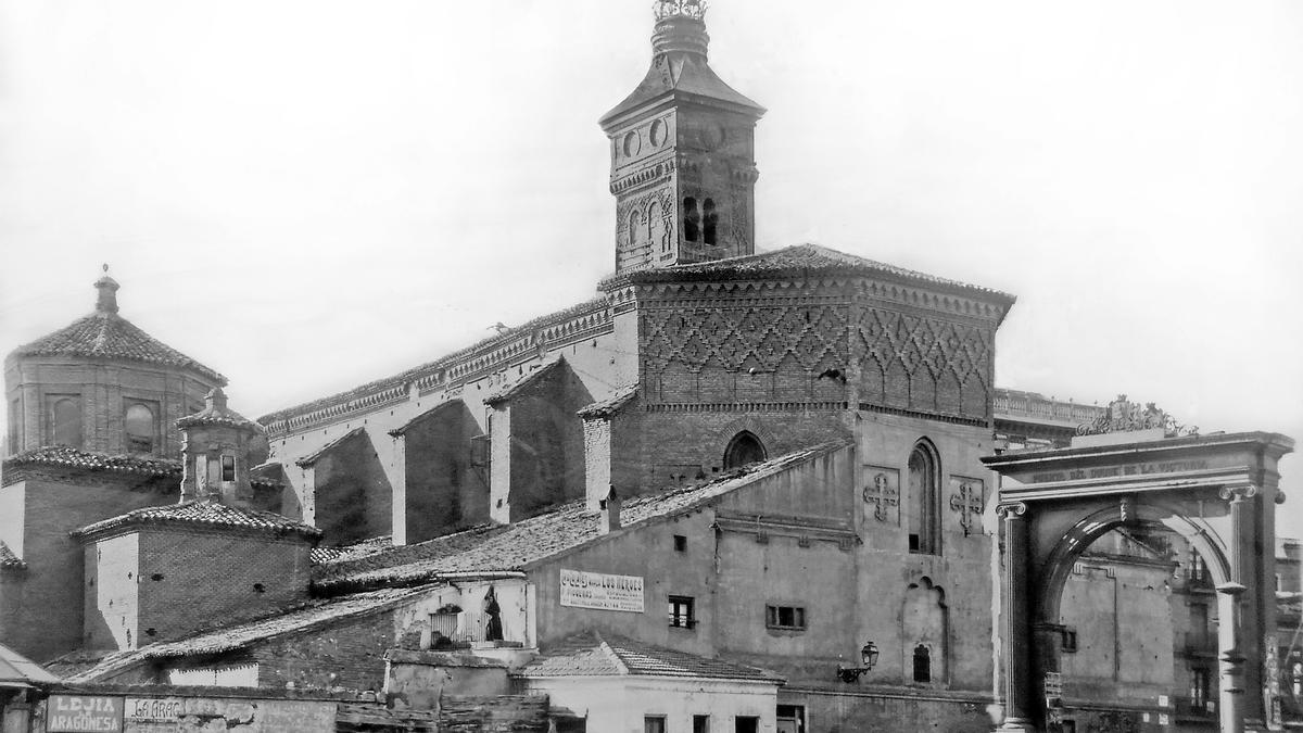 La plaza de San Miguel en una vista centrada en la iglesia parroquial que le daba nombre, en la que aparecen adosadas varias construcciones, entre ellas el fielato de la Puerta del Duque en 1918