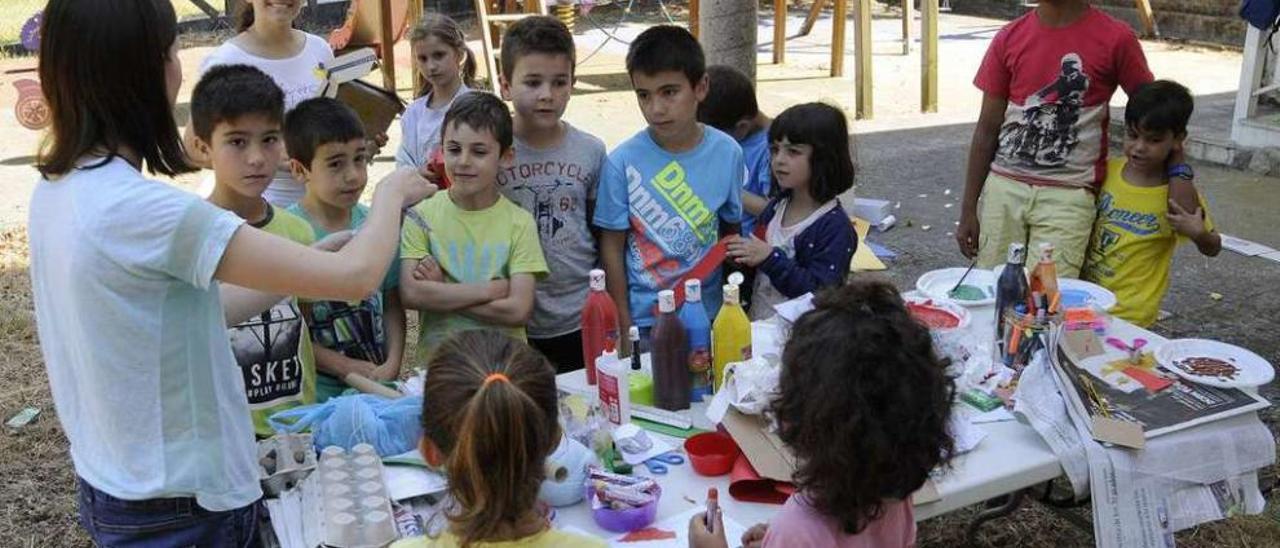 Una monitora explica a los niños una actividad de expresión plástica. // Bernabé/Javier Lalín