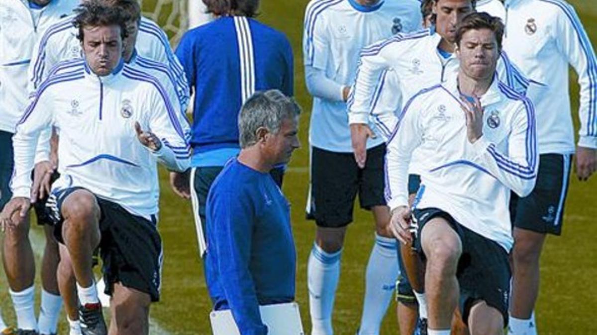 Pedro León (izquierda) y Xabier Alonso forman fila junto a Mourinho, en el entrenamiento de ayer en Madrid.