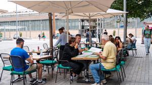 Una terraza de Barcelona, este octubre, con tazas de café, refrescos y un agua