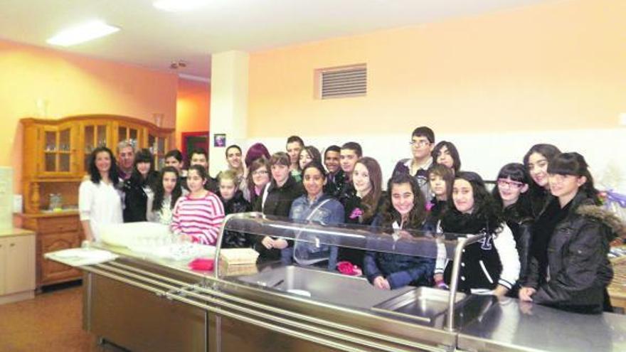 Los alumnos, con los responsables del comedor solidario, durante su visita.