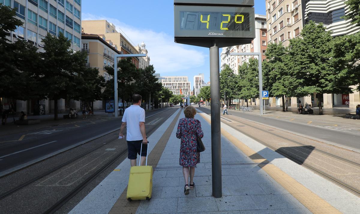 Dos personas pasean por el paseo Independencia el pasado domingo con un termómetro marcando 42 grados