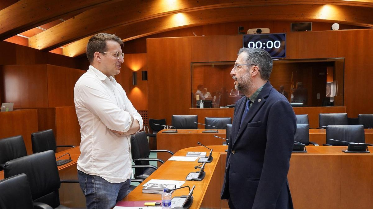 El director general de Medio Natural del Gobierno de Aragón, Óscar Fayanás, conversa con el portavoz de CHA, Jorge Pueyo, antes de comparecer en Comisión de las Cortes de Aragón.