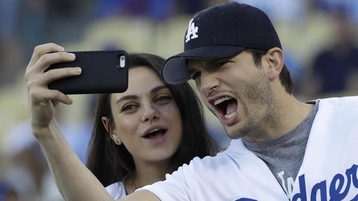 Ashton Kutcher y Mila Kunis se hacen un selfi durante un partido de baloncesto