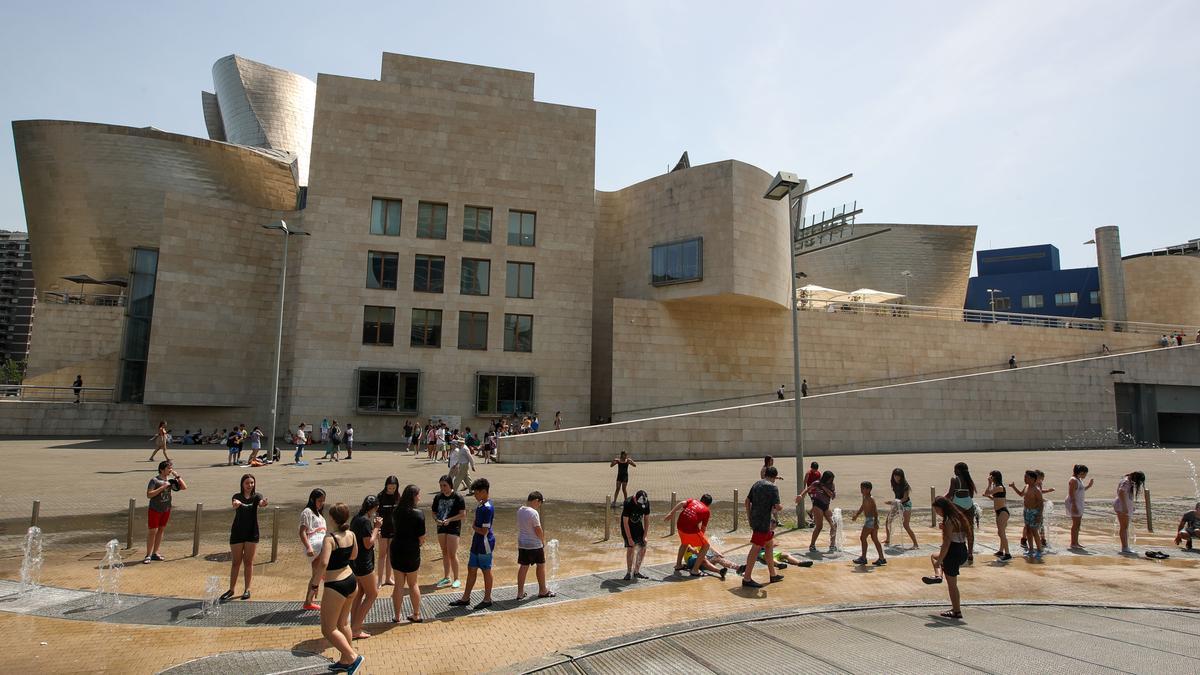 Niños se refrescan frente al Guggenheim de Bilbao.