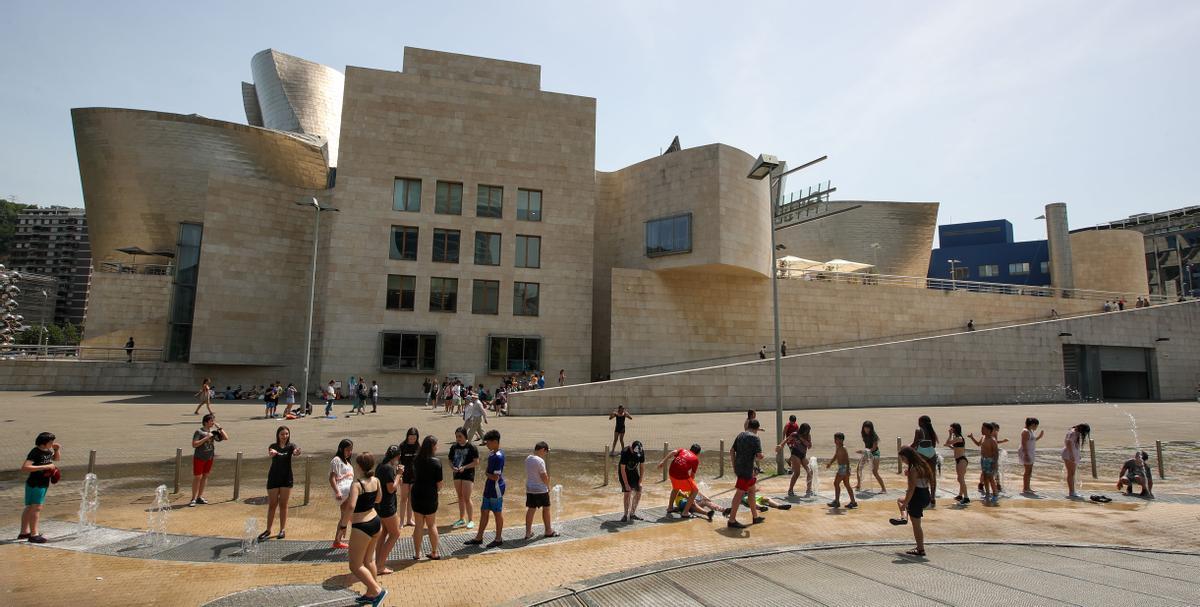 Niños se refrescan frente al Guggenheim de Bilbao.
