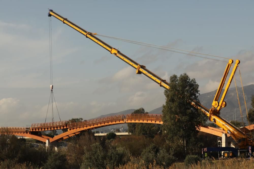 La instalación del último tramo del puente de madera sobre el río Guadalhorce ha comenzado este martes.