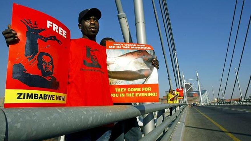 Un hombre participa en una protesta en contra del régimen del presidente de Zimbabue, Robert Mugabe, en el puente Nelson Mandela, en el centro de Johannesburgo, Sudáfrica,