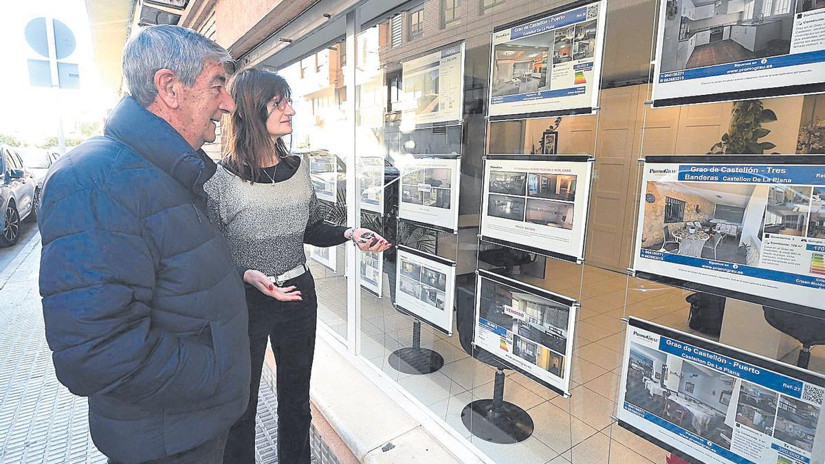 Escaparate de una agencia inmobiliaria con anuncios de viviendas a la venta en Castelló.