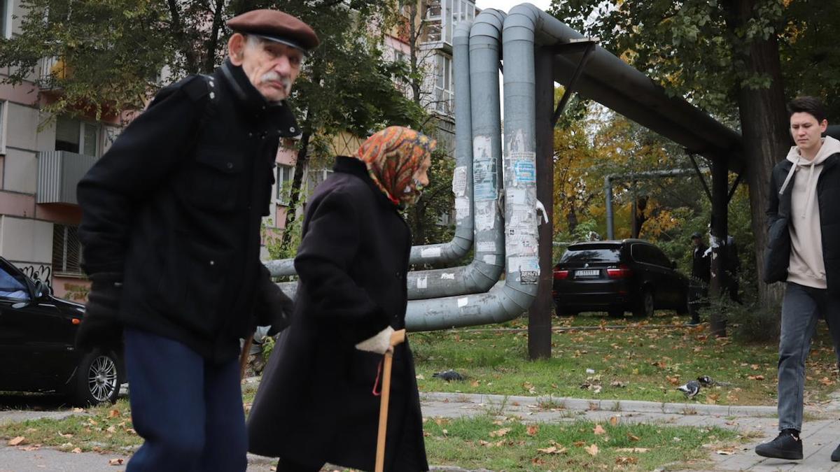 Varias personas pasan junto a las tuberías descubiertas del gas que alimentan las viviendas en Dnipro, en el centro de Ucrania.