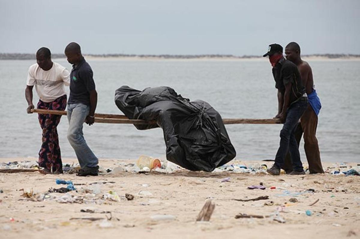 Treballadors del Govern carreguen amb el cos de Joseph Oke a la platja de Kuramo d’Illa Victoria, a Lagos, Nigèria. Oke va ser arrossegat per una enorme onada que va impactar contra la costa durant el cap de setmana. Es tem que un total de 16 persones hagin perdut la vida.