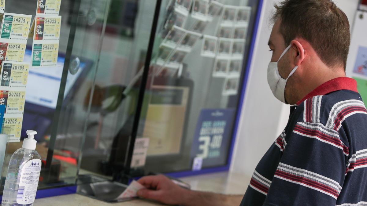 Un hombre comprando en una administración de Lotería.