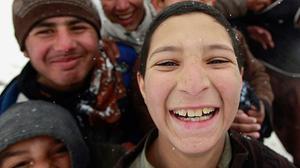 Uns nens afganesos posen davant la càmera durant una nevada a Kabul.