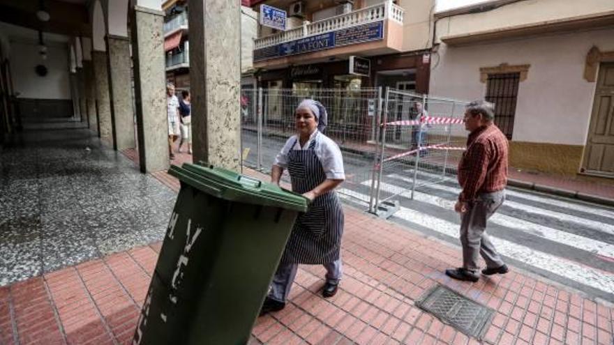 La trabajadora de un comedor de un céntrico hotel de Benidorm sale a la calle cargada con la basura.