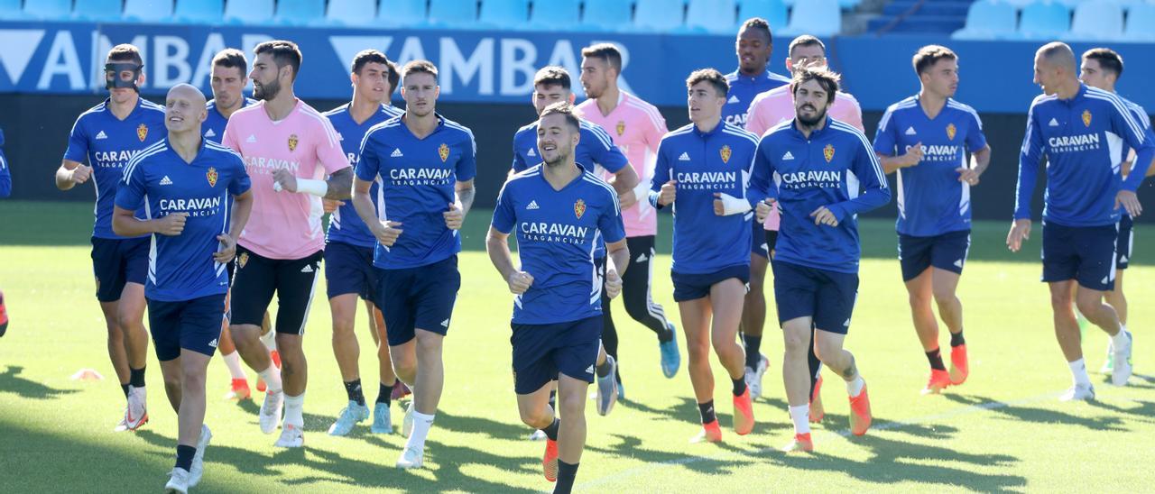 Los jugadores zaragocistas corren sobre el césped de La Romareda este viernes.