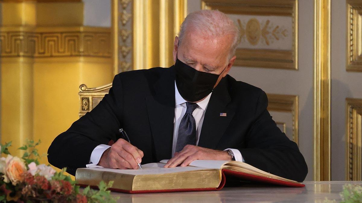 Biden firma en el libro de visitas durante su encuentro con el rey Felipe de Bélgica