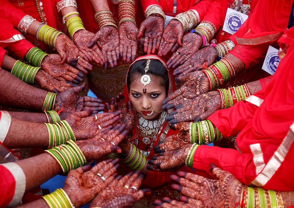 Brides display their hands decorated with henna ...
