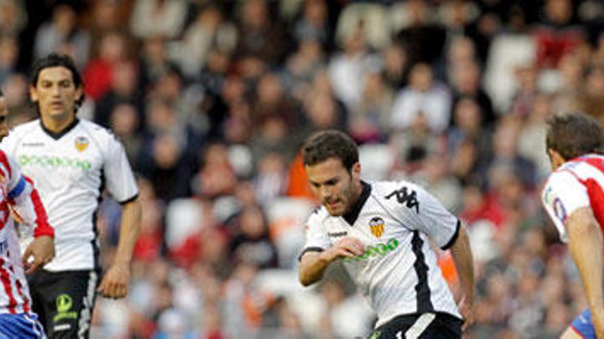 Pugna por el balón entre jugadores de Sporting y Valencia en Mestalla.