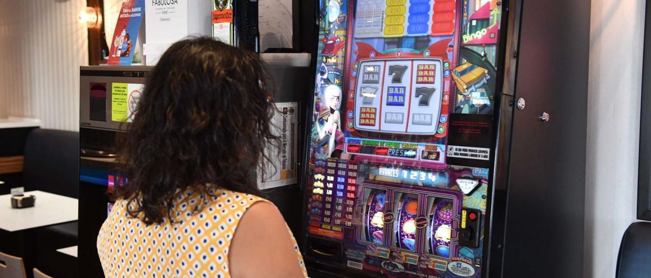 Una mujer juega a una máquina tragaperras en una cafetería de A Coruña.