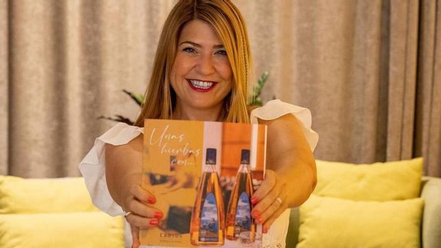 La autora muestra la portada de su libro en Ebusus.