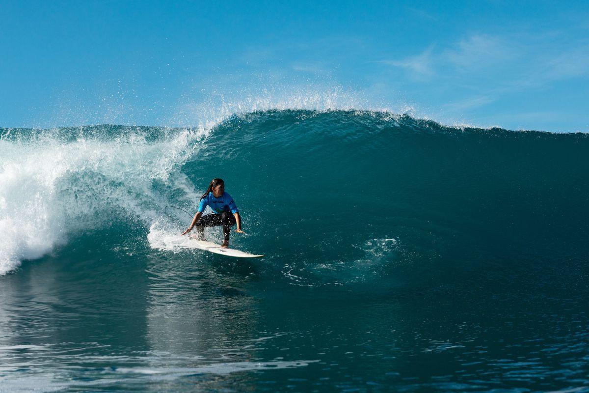 Una mujer surfeando.