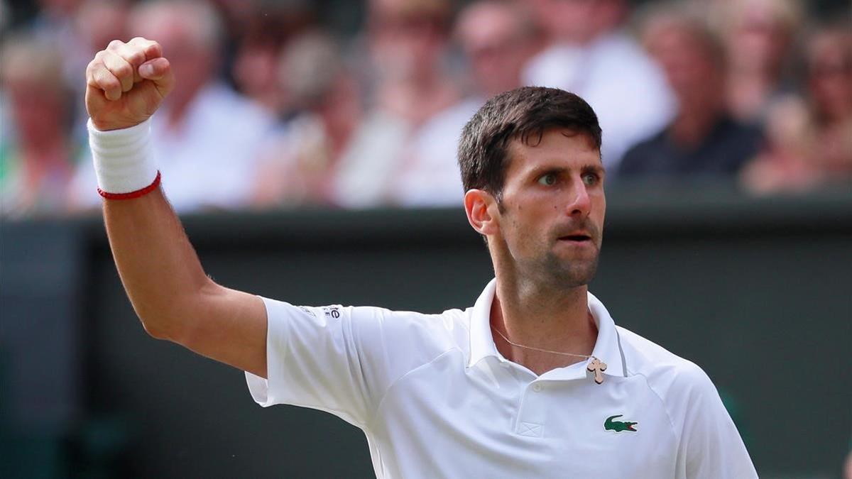 Djokovic celebra un punto ante Federer en la final de Wimbledon.
