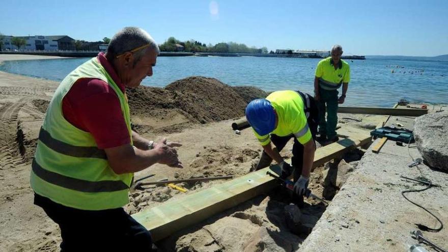 Los trabajos de instalación de la plataforma de madera en la playa de O Preguntoiro. // Iñaki Abella