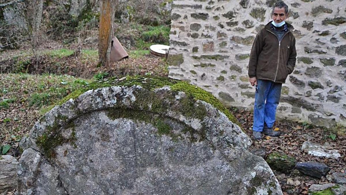 Un vecino observa una piedra de molienda expuestas en el exterior. | A. S.