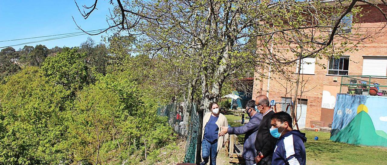 Docentes, arquitecto y alcalde observan el monte que se unirá al patio del colegio A Cruz.