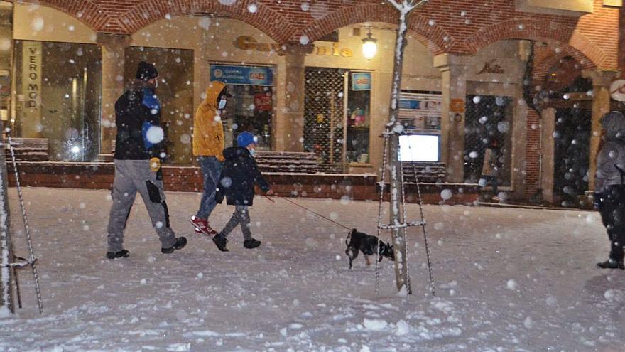 Una familia paseando el perro por Santa María. | E. P.