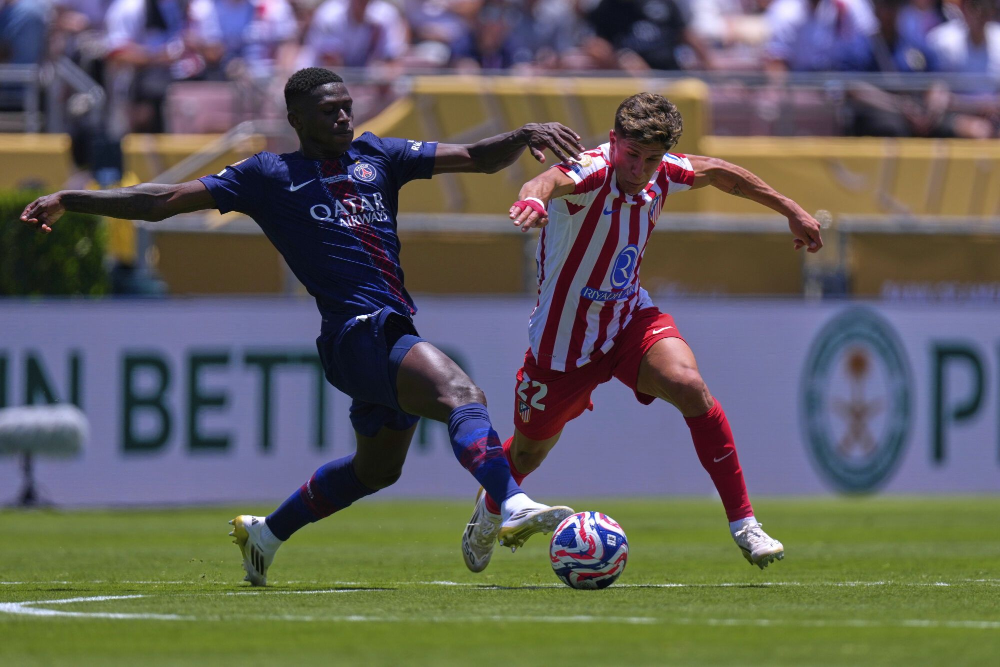 Paris Saint-Germain's Nuno Mendes, left, vies for the ball with Atletico Madrid's Giuliano Simeone during the Club World Cup group B soccer match between PSG and Atletico Madrid, in Pasadena, Calif., Sunday, June 15, 2025. (AP Photo/Mark J. Terrill)