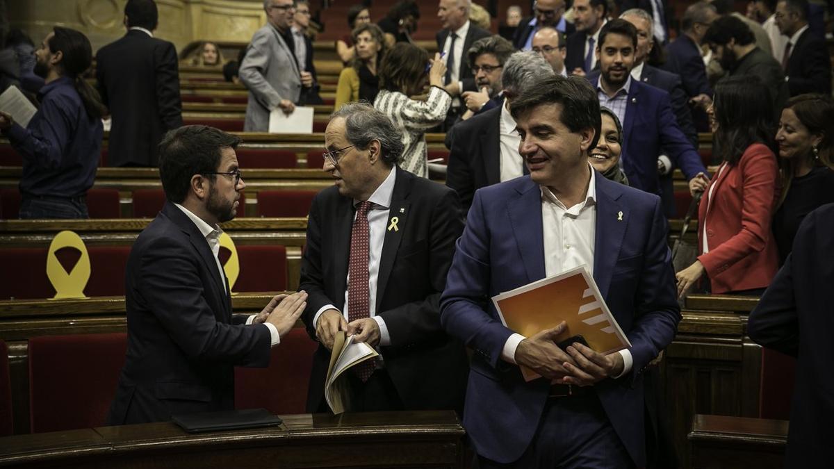 Sabrià pasa junto a Torra y Aragonès, en el Parlament.