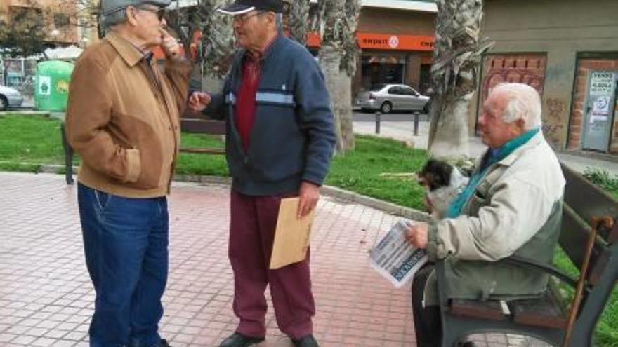 Antonio conversa con otros dos jubilados sobre las pensiones en un parque de Alicante.