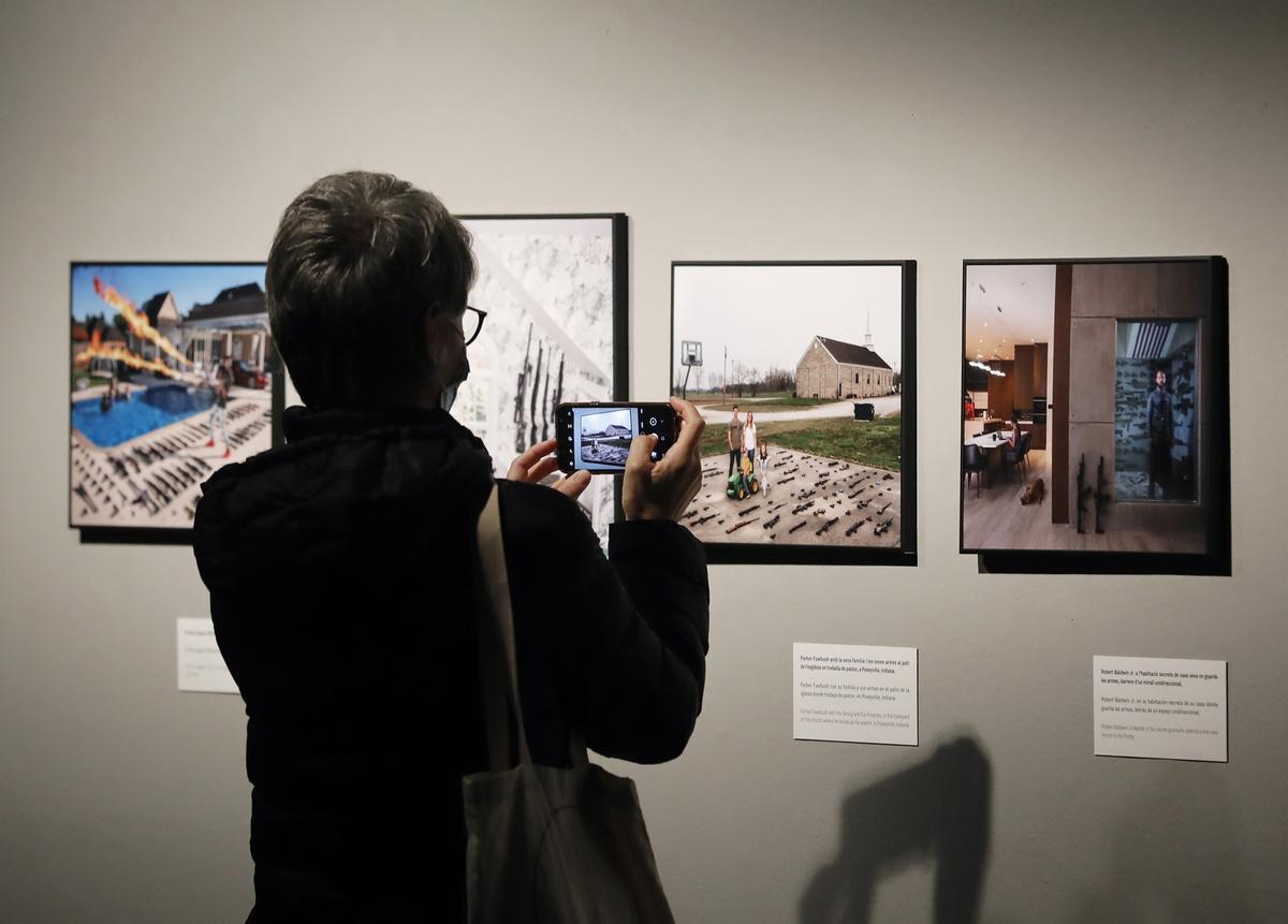Una mujer saca una foto de algunas de las imágenes presentes en la exposición World Press Photo 2021, en el CCCB de Barcelona.