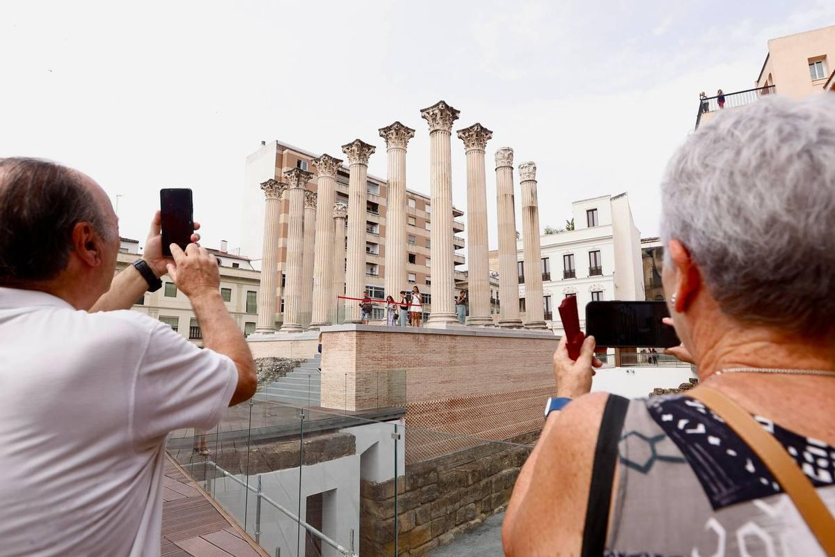 Dos visitantes fotografían las columnas del Templo Romano.