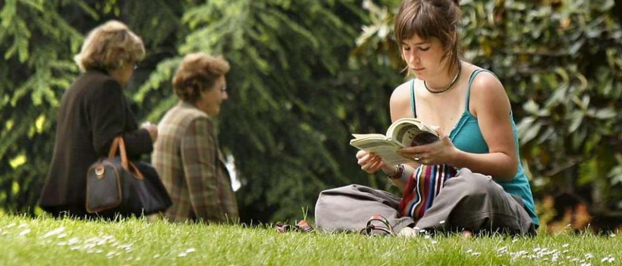 Una joven lee un libro en un parque. // Efe