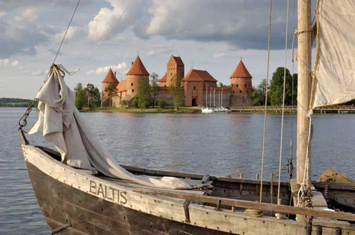 Bote tradicional sobre el lago Galve con el castillo de Trikai al fondo.
