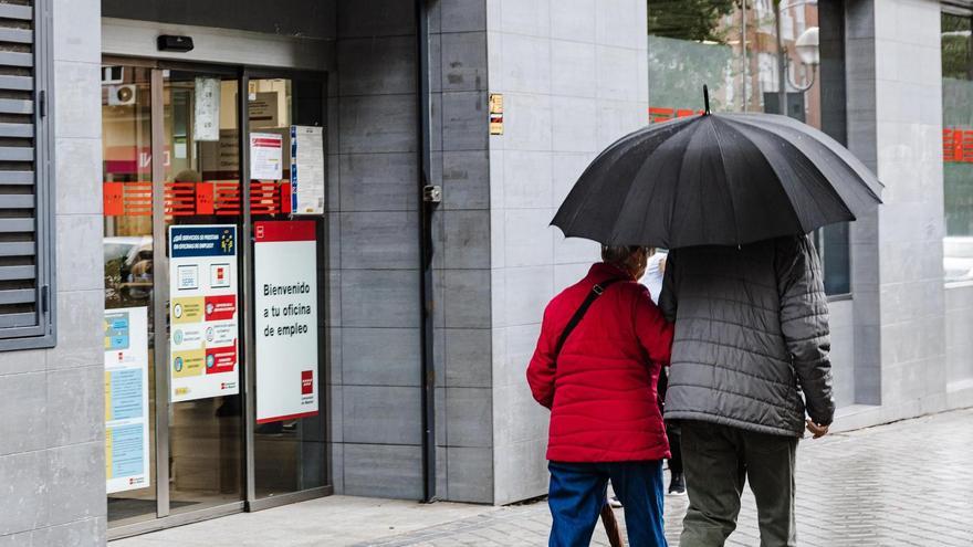 Dos personas pasan junto auna oficina de empleo.