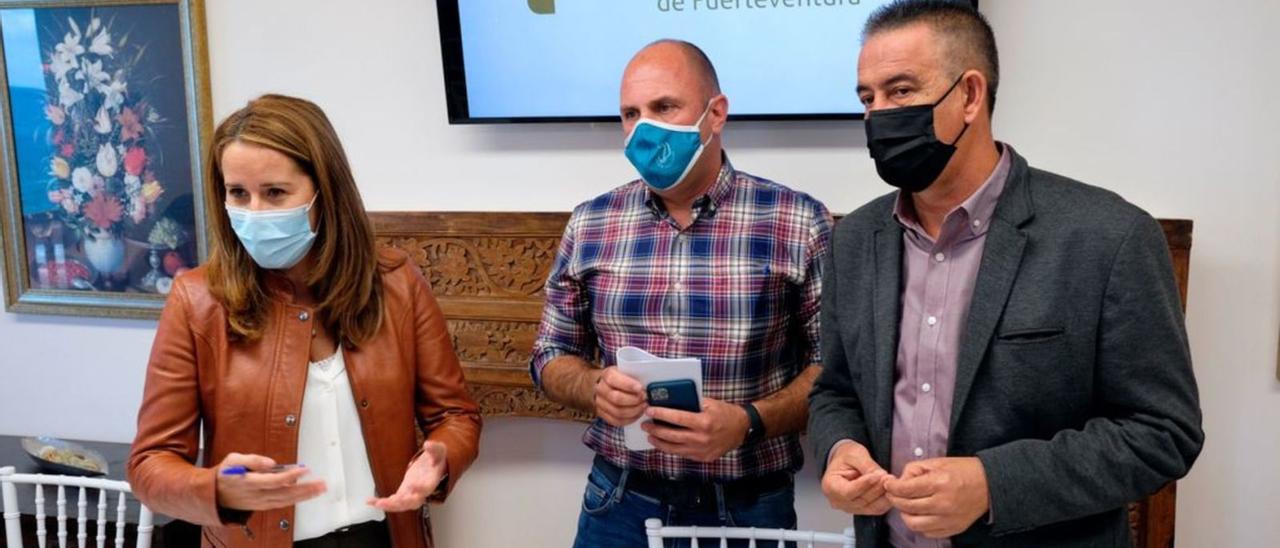 Lola García (i), Sergio Lloret (c) y Claudio Gutiérrez (d) durante la presentación del nuevo pacto en el Cabildo, en febrero de 2021. | | CARLOS DE SAÁ / EFE